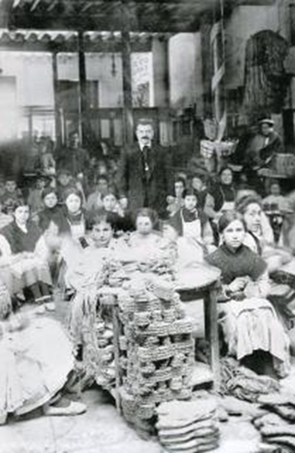 Interior de la fábrica de alpargatas de D. Juan Orts Miralles, de Elche, posando con sus trabajadores, la mayoría mujeres y niñas (1912)